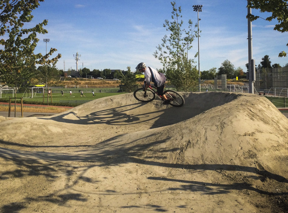 A rider cruises around the lower berm to build speed to get back up to the top of the track.